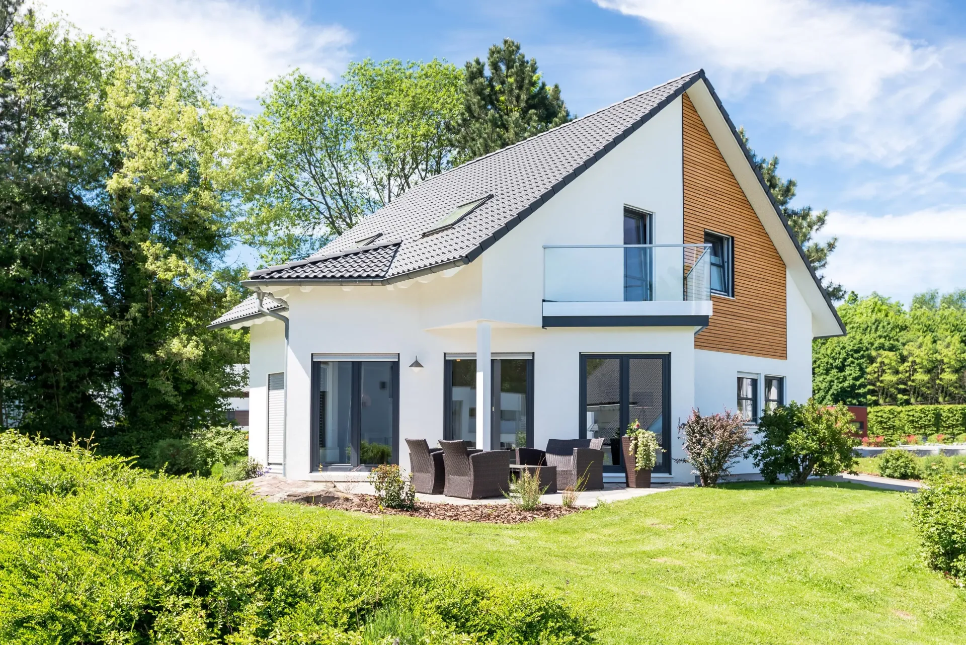 Maison résidentielle contemporaine à façade blanche avec jardin arboré.